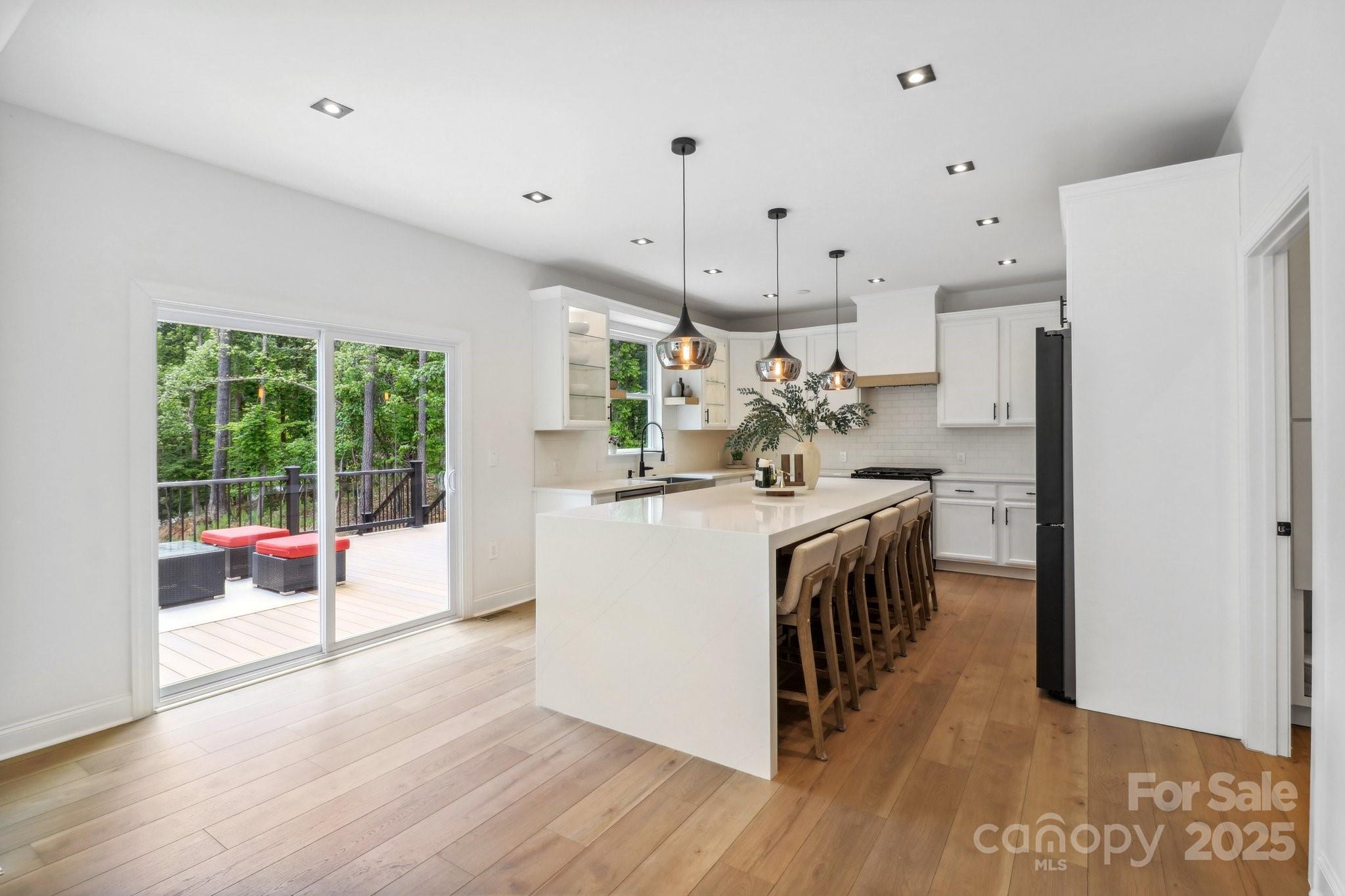 545 Morrison Farm Road Troutman, NC 28166 - Photo 9 of 31 a kitchen with kitchen island wooden floor center island and stainless steel appliances