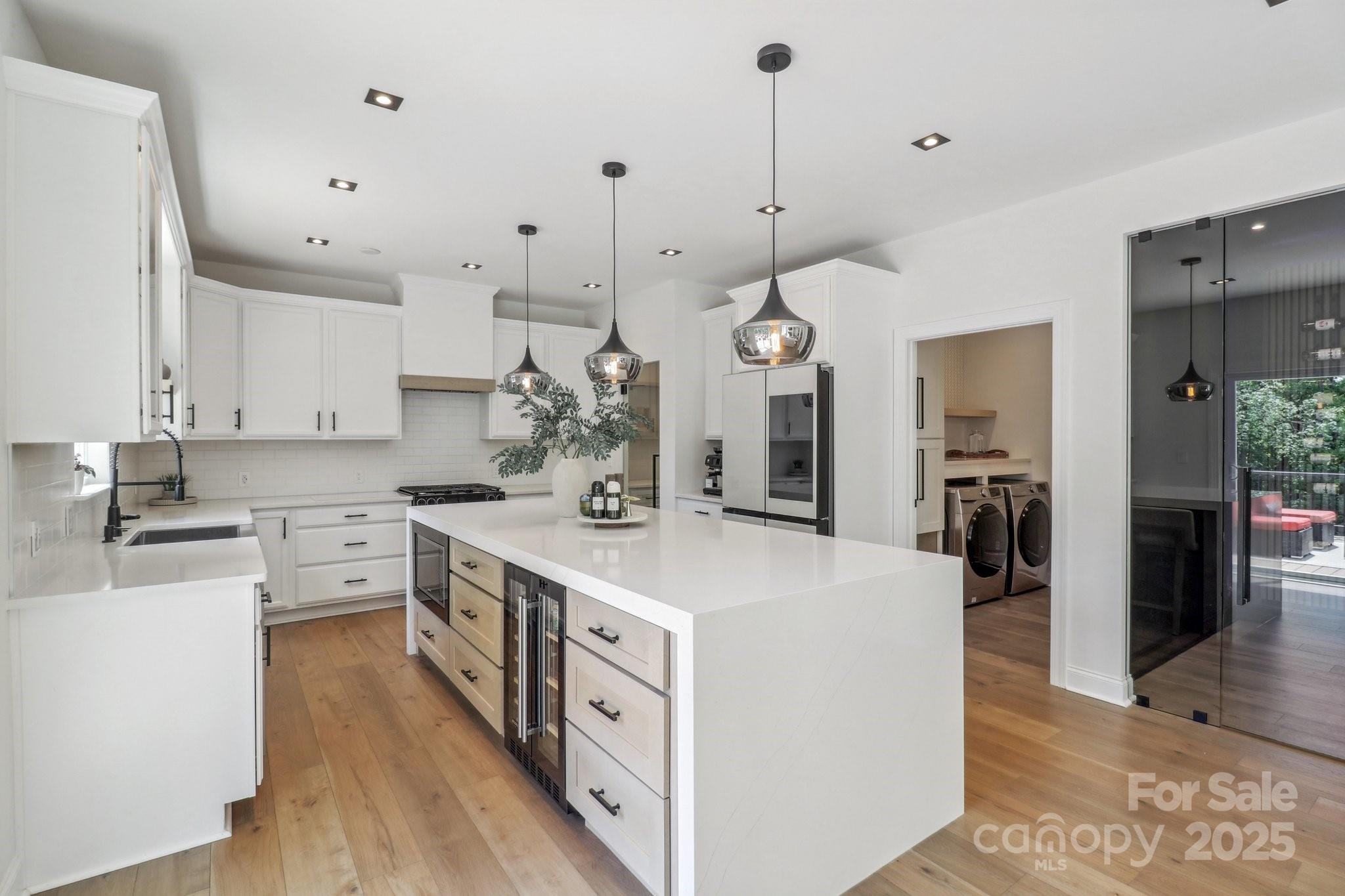 545 Morrison Farm Road Troutman, NC 28166 - Photo 10 of 31 a large kitchen with kitchen island a stove a sink a center island and stainless steel appliances