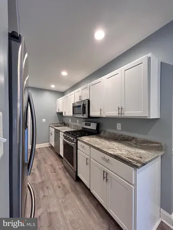 a kitchen with stainless steel appliances granite countertop a stove a sink and a refrigerator