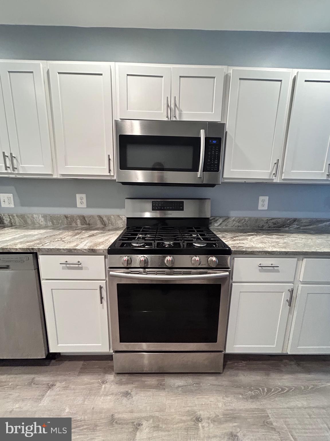 3541 3rd Street Baltimore, MD 21225 - Photo 7 of 37 a kitchen with stainless steel appliances granite countertop a stove a microwave and cabinets