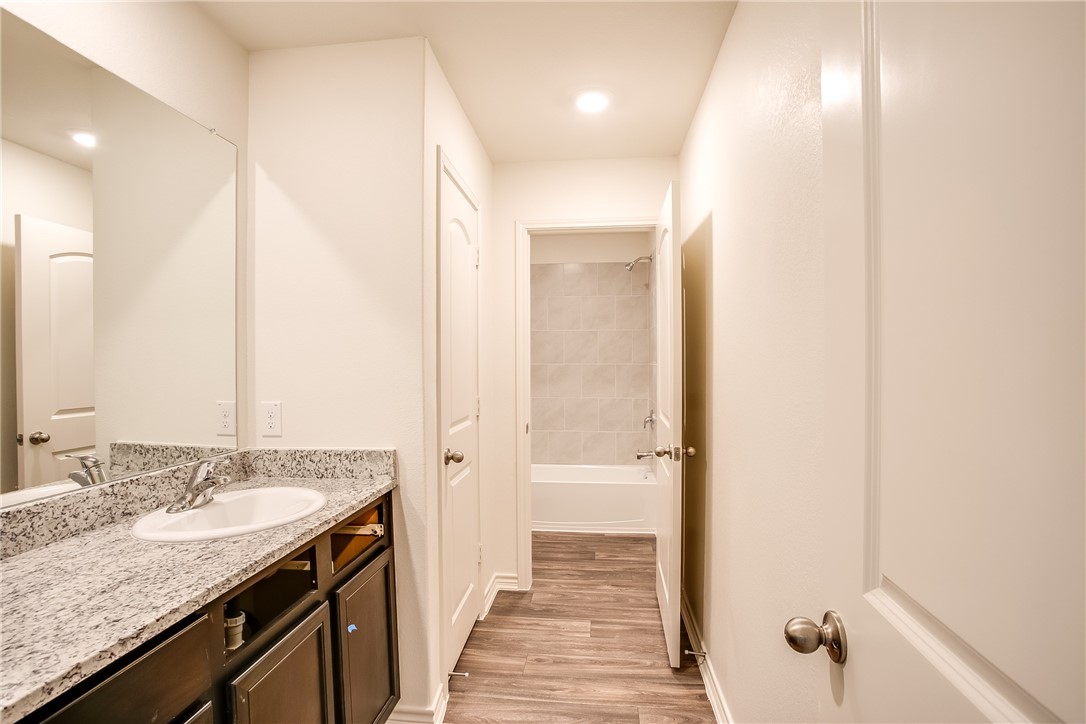19024 Quiet Range Drive Elgin, TX 78621 - Photo 23 of 30 a bathroom with a granite countertop sink and a mirror