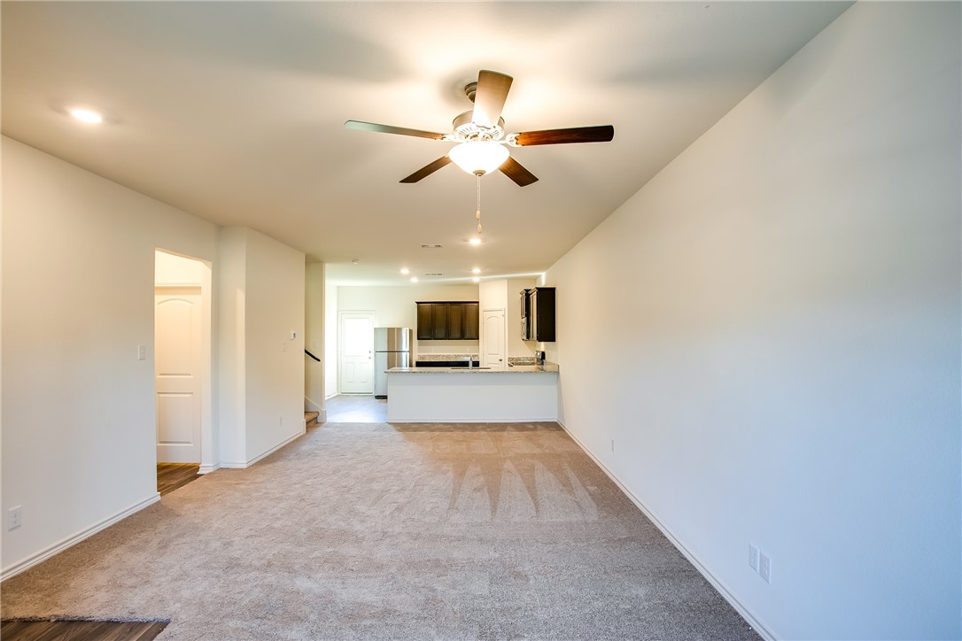 19024 Quiet Range Drive Elgin, TX 78621 - Photo 5 of 30 a view of a livingroom with a chandelier fan and a kitchen