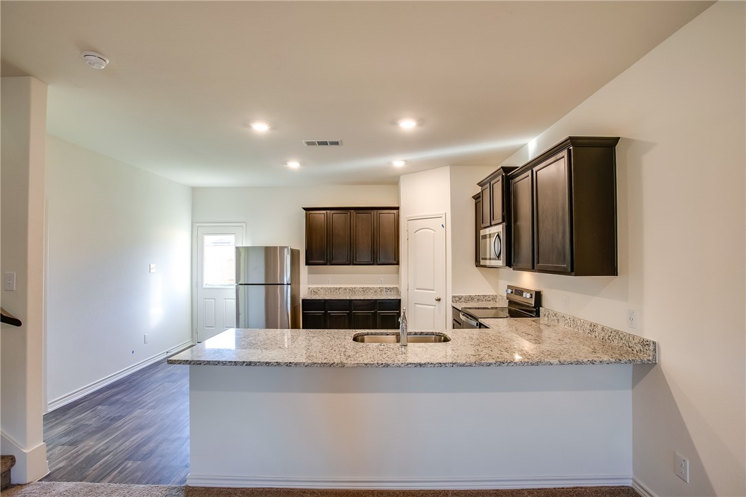 19024 Quiet Range Drive Elgin, TX 78621 - Photo 8 of 30 a kitchen with stainless steel appliances a sink and a microwave