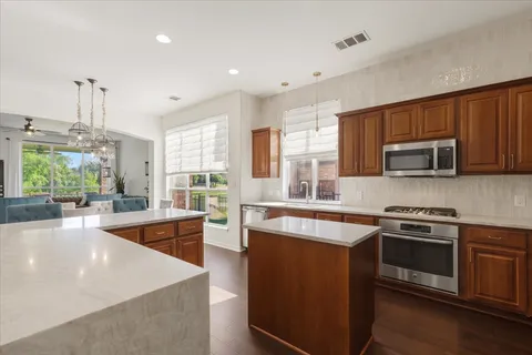 a kitchen with stainless steel appliances granite countertop a stove a sink and a microwave