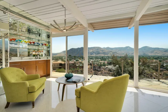 a view of a living room with a table and chairs