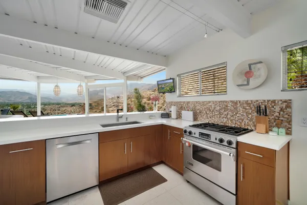 a view of a kitchen with a sink and large window