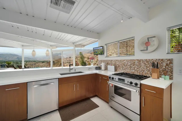 a view of a kitchen with a sink and large window
