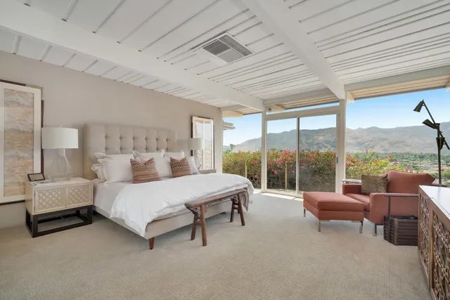 a bedroom with a bed and large window