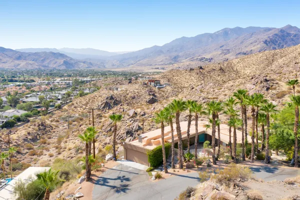 a front view of a house with swimming pool and outdoor seating
