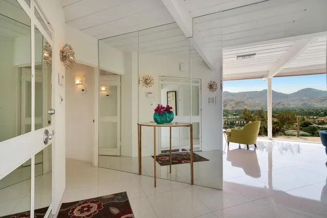 a living room with patio furniture and a potted plants