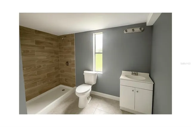a bathroom with a toilet sink vanity and shower