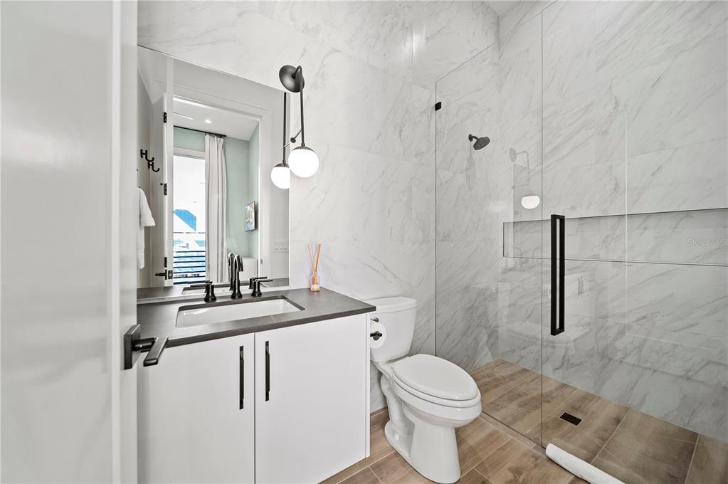 7007 Point Of Rocks Road Sarasota, FL 34242 - Photo 32 of 62 a bathroom with a granite countertop sink a toilet and a mirror