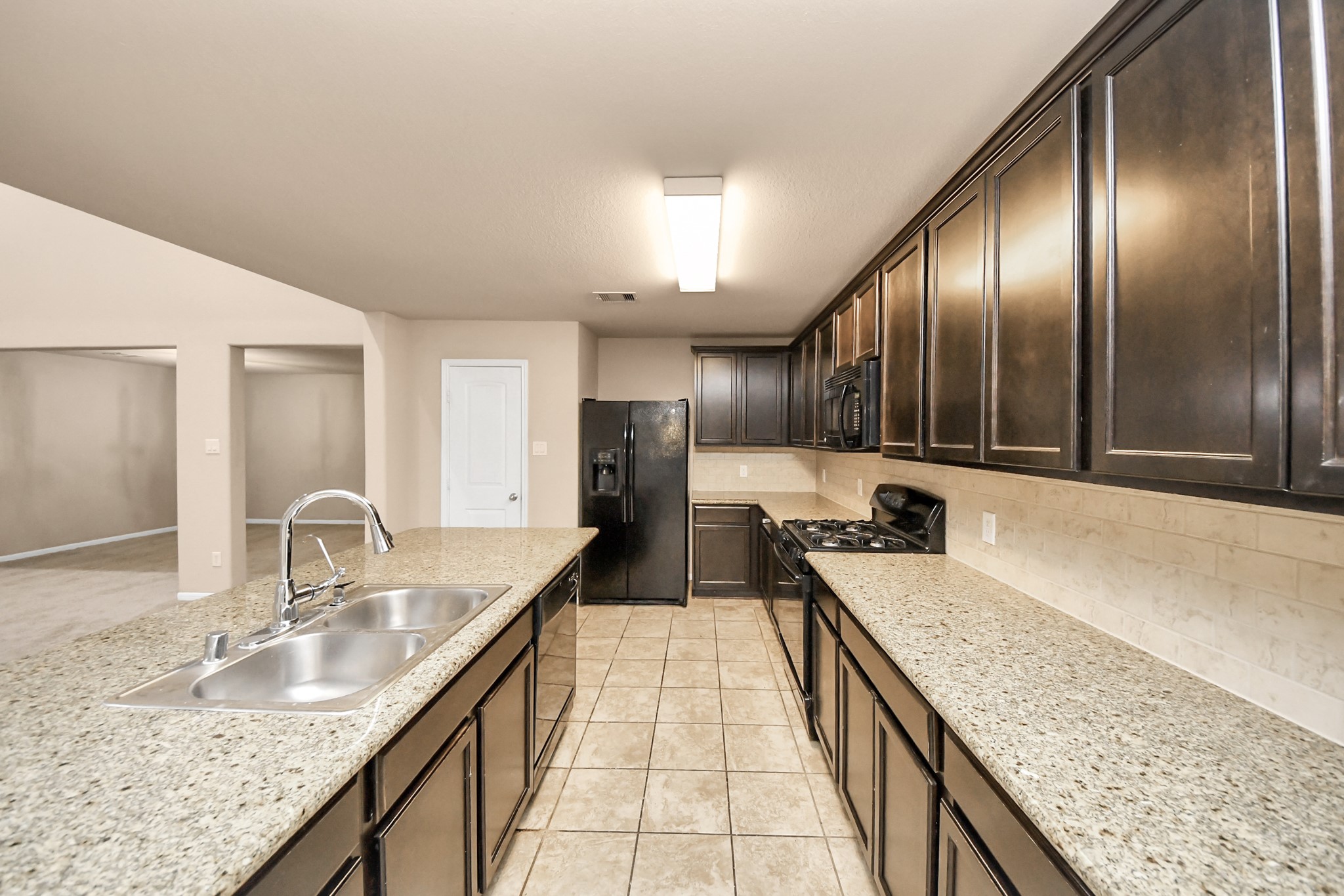 9326 Limestone Ranch Lane Richmond, TX 77407 - Photo 33 of 50 a large kitchen with granite countertop a sink and a refrigerator