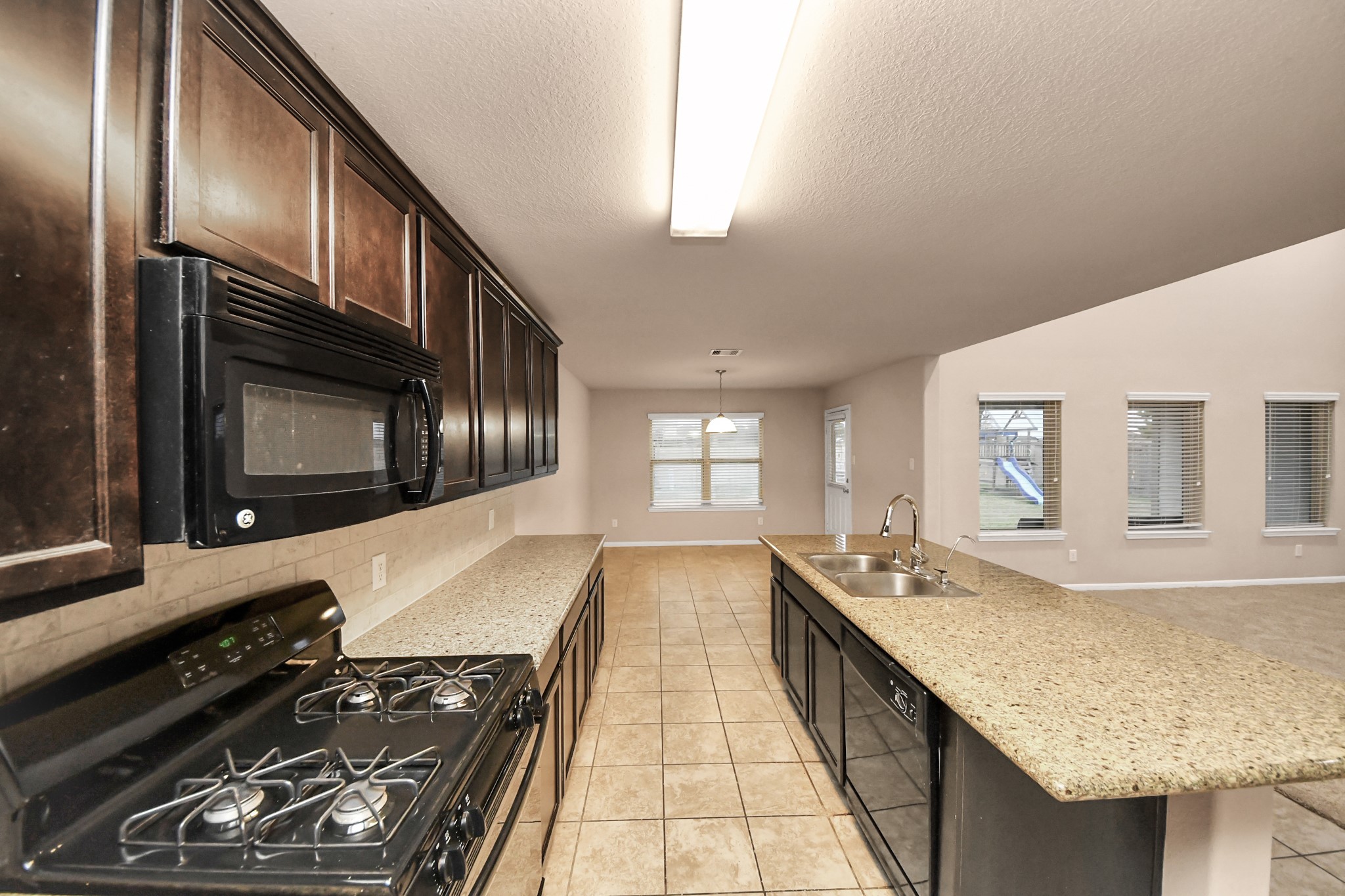9326 Limestone Ranch Lane Richmond, TX 77407 - Photo 35 of 50 a kitchen with kitchen island granite countertop a stove and a sink