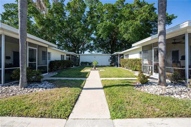 a view of a house with backyard and sitting area