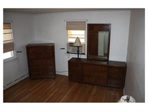 407 Florida Grove Road Perth Amboy, NJ 08861 - Photo 8 of 9 a living room with a mirror and a wooden floor
