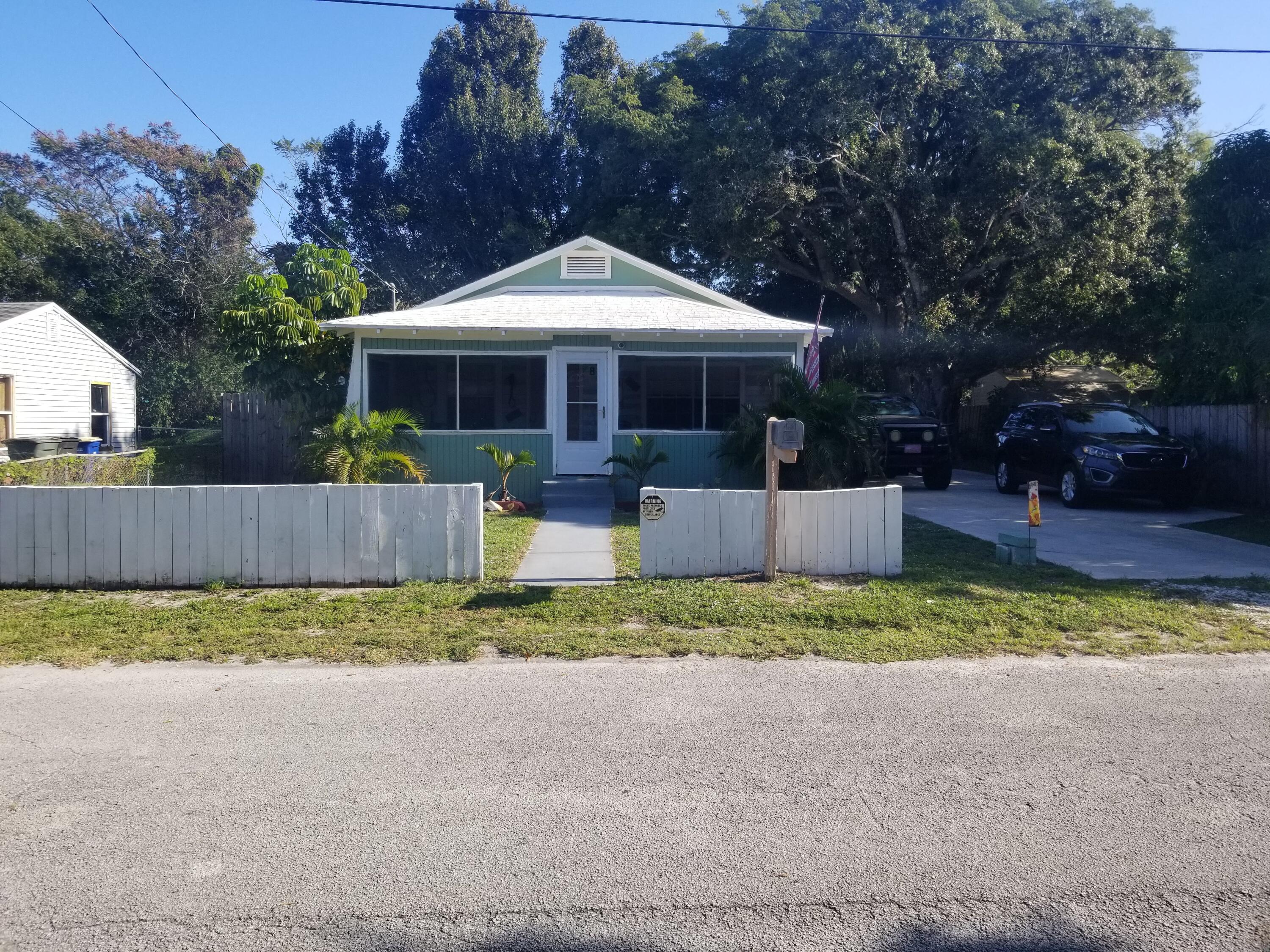1224 Raymond Avenue Fort Pierce, FL 34950 - Photo 1 of 27 a front view of a house with a yard and garage