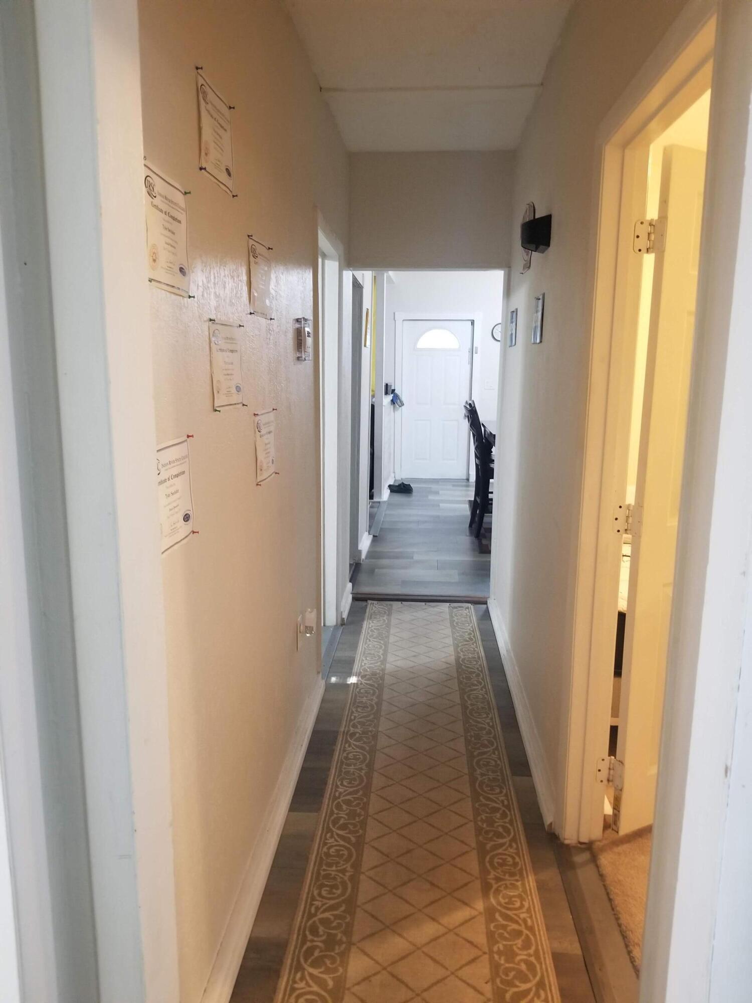 1224 Raymond Avenue Fort Pierce, FL 34950 - Photo 12 of 27 a view of a hallway with wooden floor and a bathroom