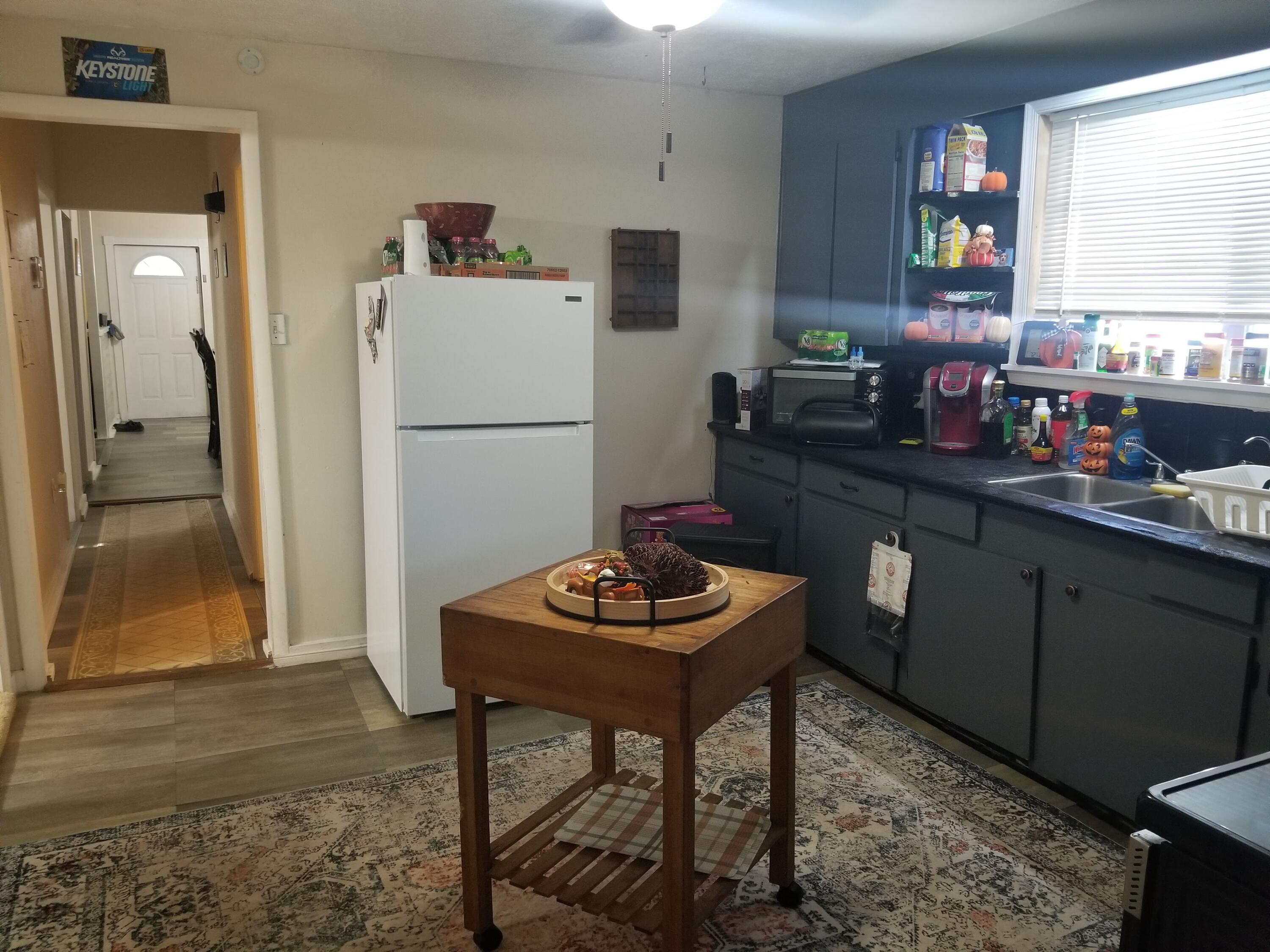 1224 Raymond Avenue Fort Pierce, FL 34950 - Photo 14 of 27 a kitchen with a refrigerator and a table