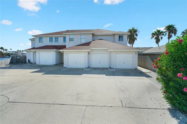 a view of a house with a yard and potted plants