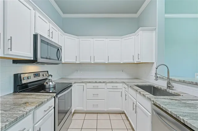 a kitchen with stainless steel appliances granite countertop a sink stove and cabinets