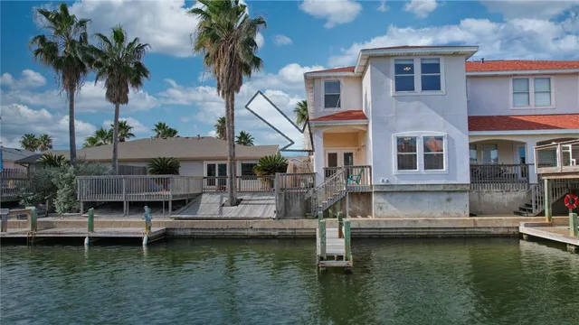 a white house that has a small yard with a large pool