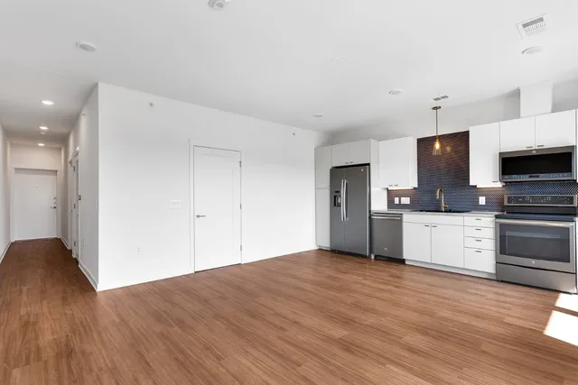 a kitchen with stainless steel appliances a refrigerator and a stove top oven