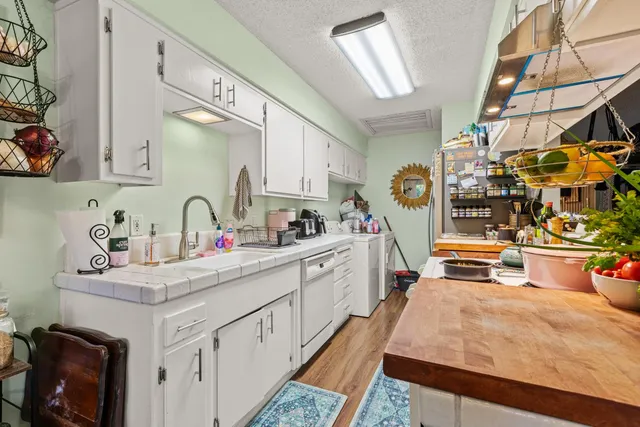 a kitchen that has a lot of cabinets in it and wooden floor