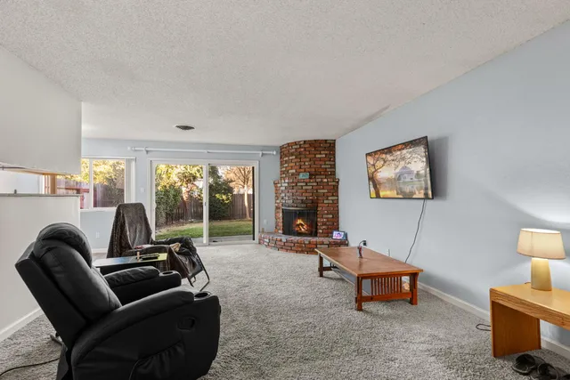 a living room with furniture a large window and a flat screen tv