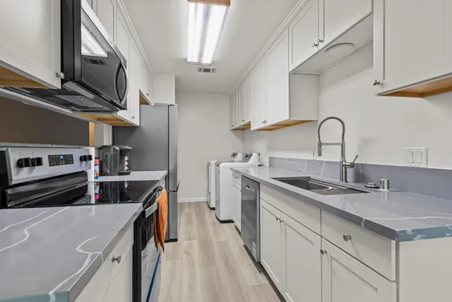a kitchen with stainless steel appliances granite countertop a sink stove and cabinets