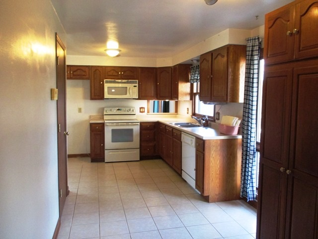 4718 Highcrest Road Rockford, IL 61107 - Photo 8 of 20 a kitchen with stainless steel appliances granite countertop a stove a sink and a refrigerator