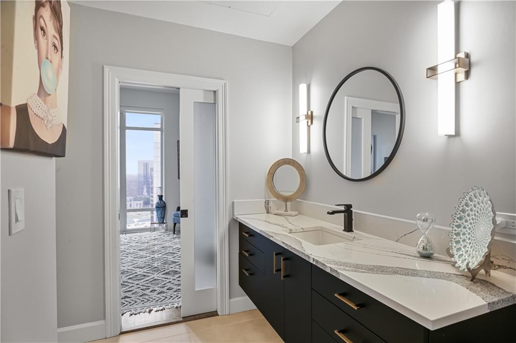 3445 Stratford Road Northeast, Unit 3703 Atlanta, GA 30326 - Photo 31 of 59 a bathroom with a granite countertop sink a mirror and a shower