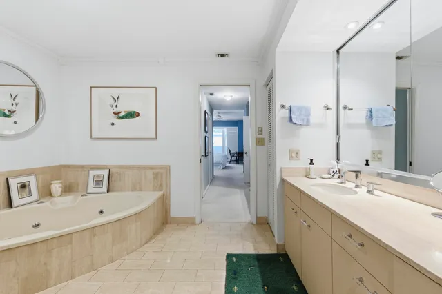 a spacious bathroom with a tub sink and mirror