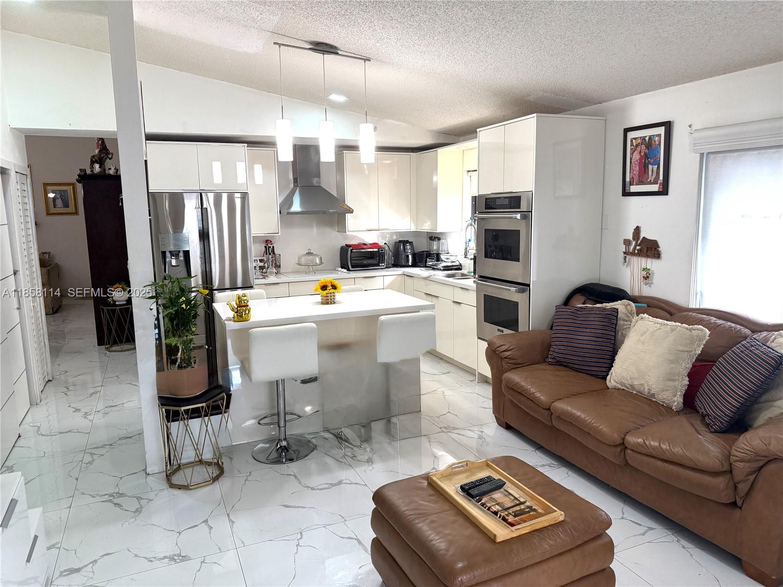 11266 Southwest 33rd Street Miami, FL 33165 - Photo 11 of 19 a living room with furniture a flat screen tv and a refrigerator