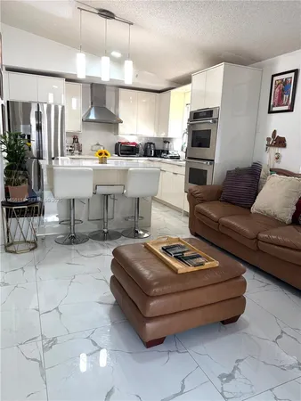a living room with furniture and a kitchen view