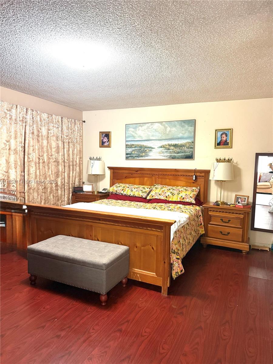 11266 Southwest 33rd Street Miami, FL 33165 - Photo 16 of 19 a spacious bedroom with a bed and wooden floor