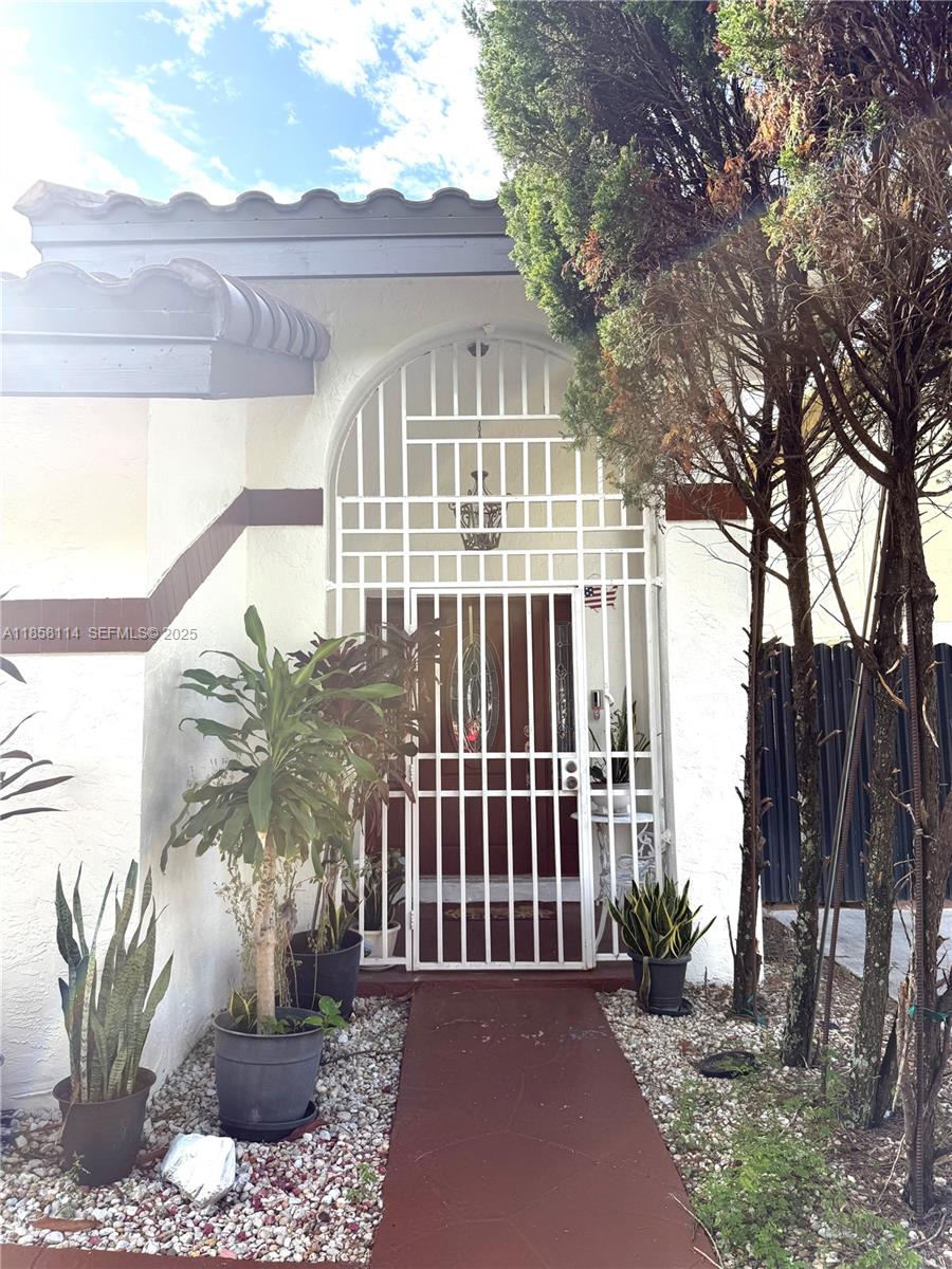 11266 Southwest 33rd Street Miami, FL 33165 - Photo 2 of 19 a view of a white house with a small yard and plants