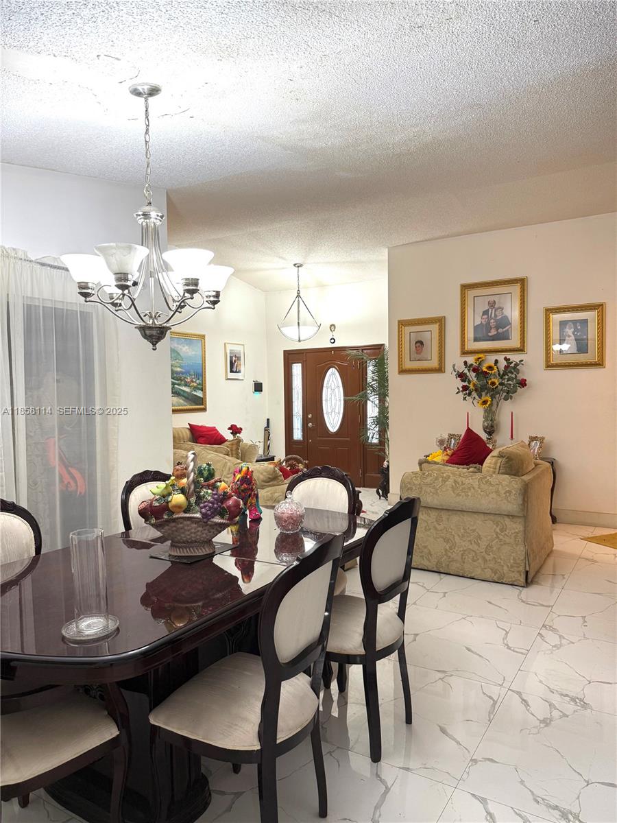 11266 Southwest 33rd Street Miami, FL 33165 - Photo 5 of 19 a living room with furniture and kitchen chandelier