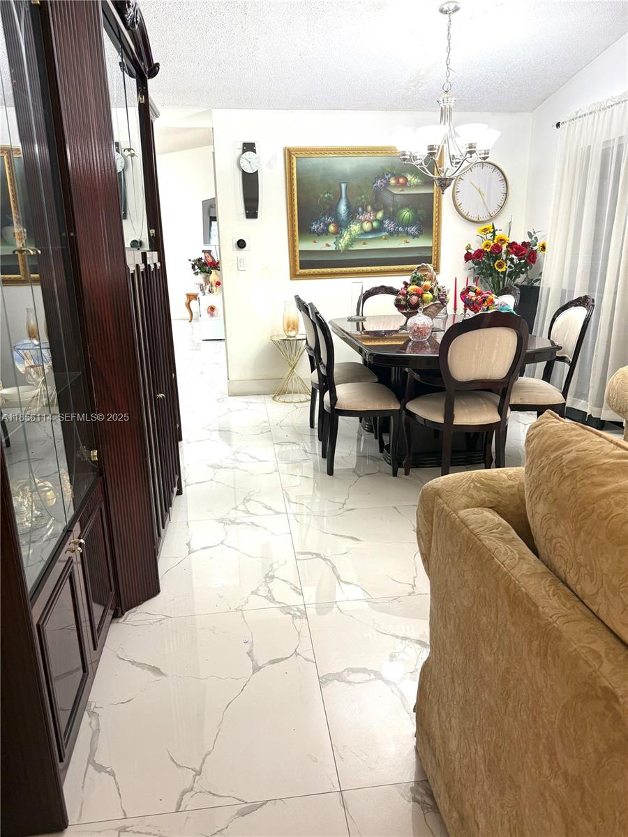 11266 Southwest 33rd Street Miami, FL 33165 - Photo 7 of 19 a living room with furniture and a chandelier