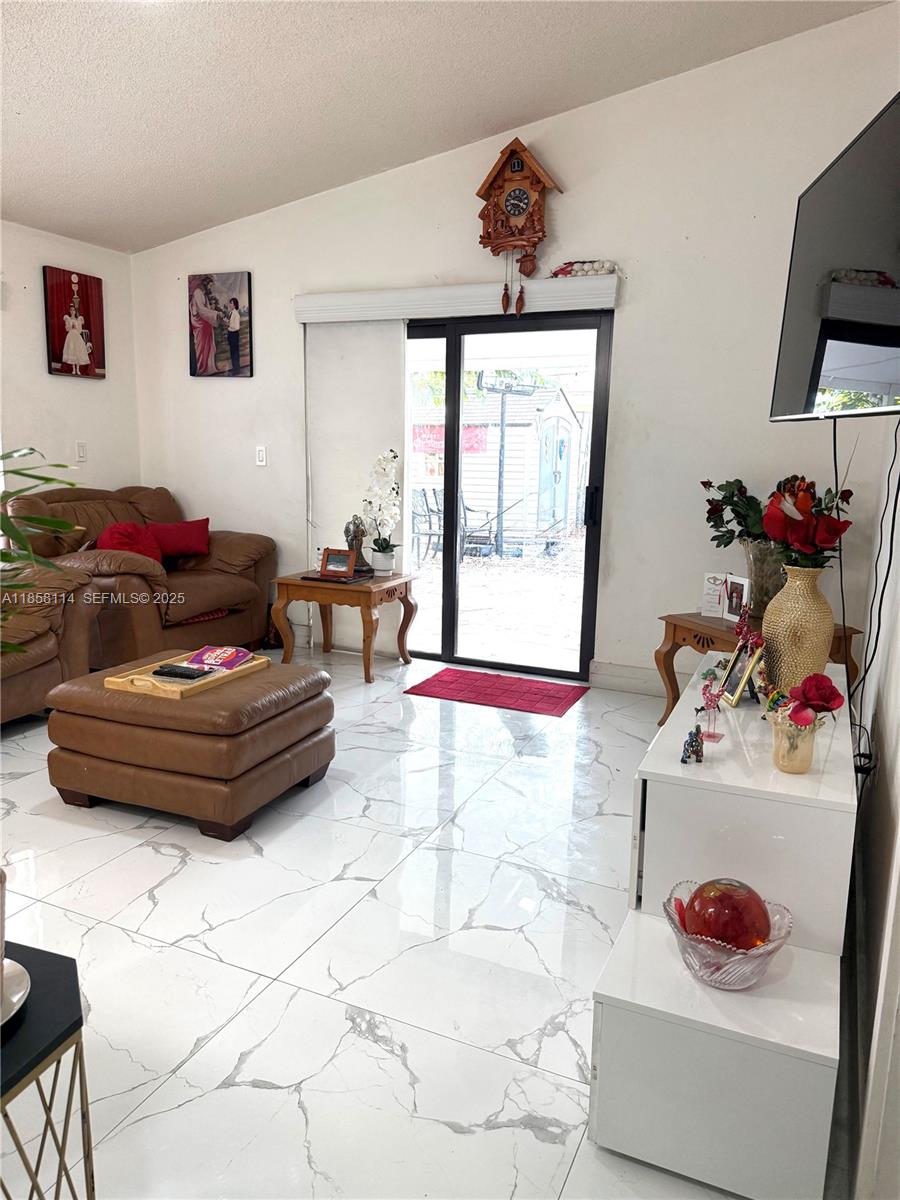 11266 Southwest 33rd Street Miami, FL 33165 - Photo 9 of 19 a living room with furniture and a flat screen tv