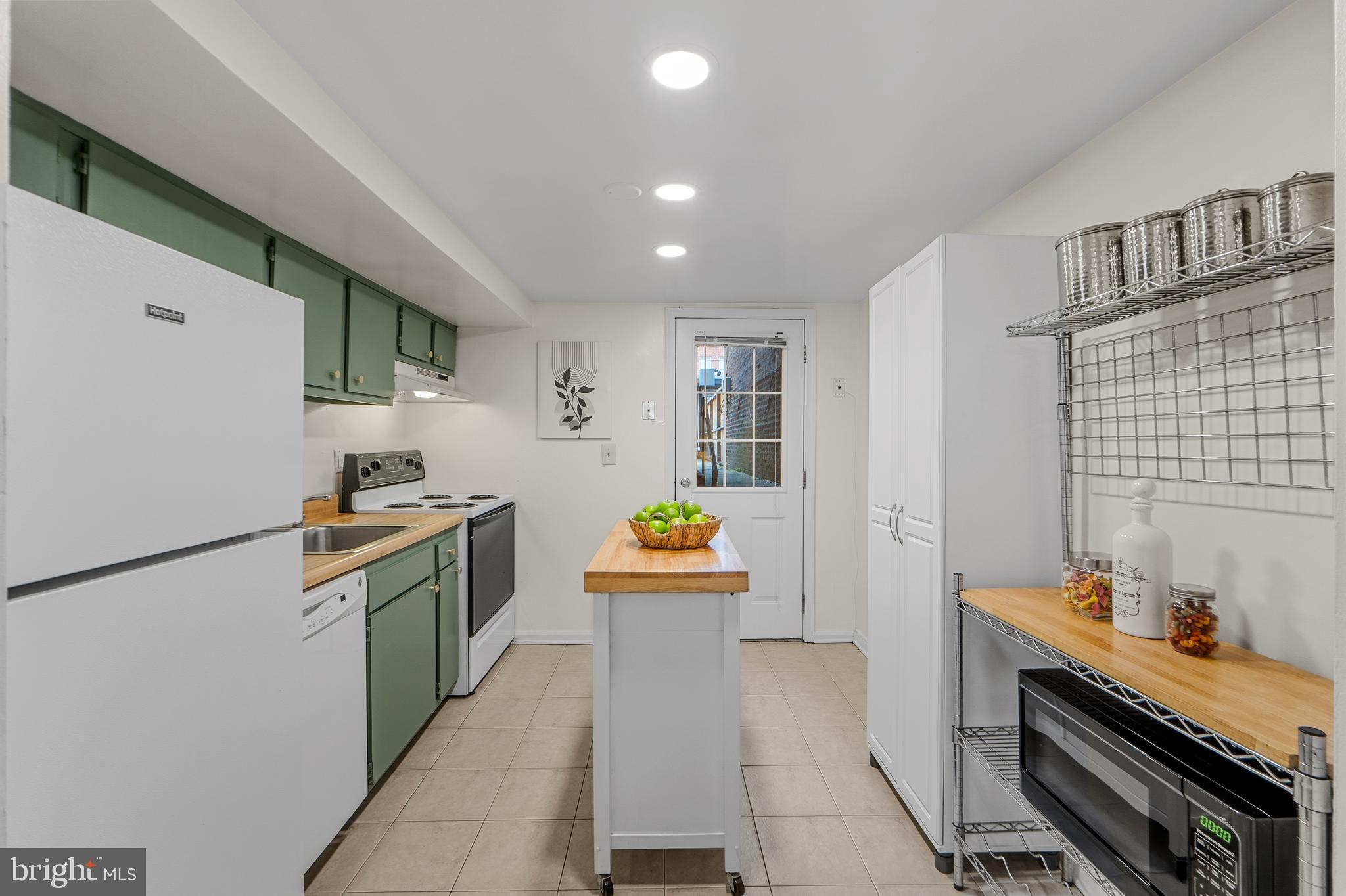 1927 15th Street Northwest Washington, DC 20009 - Photo 43 of 59 a kitchen with stainless steel appliances kitchen island wooden cabinets and stove top oven