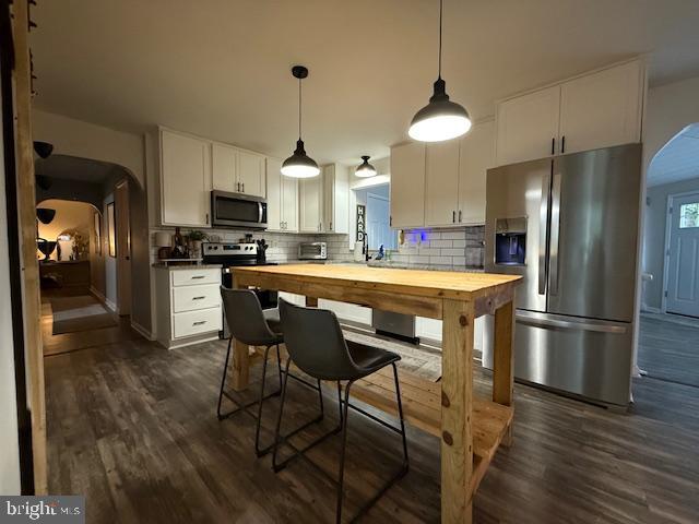 37181 Asher Road Mechanicsville, MD 20659 - Photo 13 of 50 a kitchen with stainless steel appliances a dining table chairs refrigerator and stove
