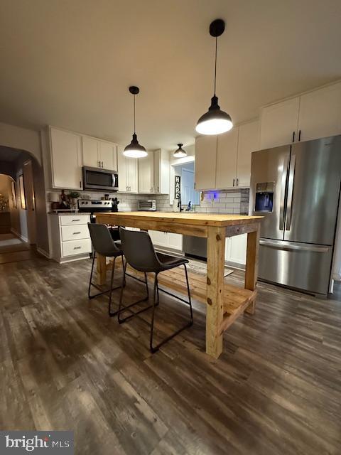 37181 Asher Road Mechanicsville, MD 20659 - Photo 14 of 50 a kitchen with stainless steel appliances a dining table chairs a stove and a refrigerator