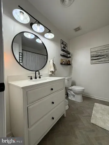 a bathroom with a sink a toilet and mirror