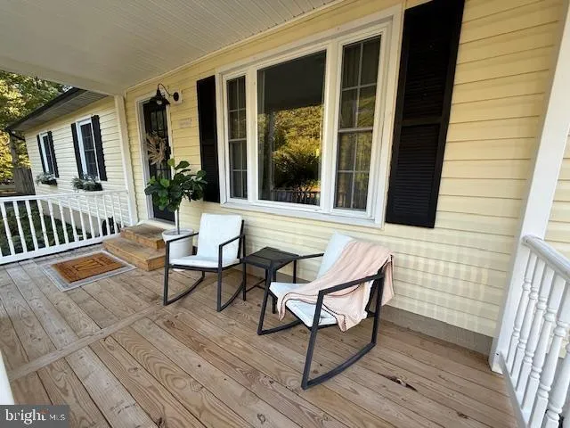 a balcony with wooden floor and outdoor seating