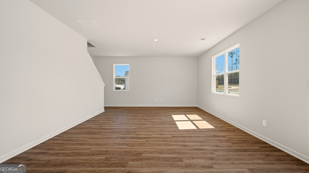 8578 Seabiscuit Road Lithonia, GA 30058 - Photo 13 of 30 a view of an empty room with wooden floor and a window