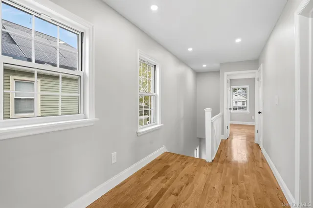 a view of hallway with wooden floor and chandelier