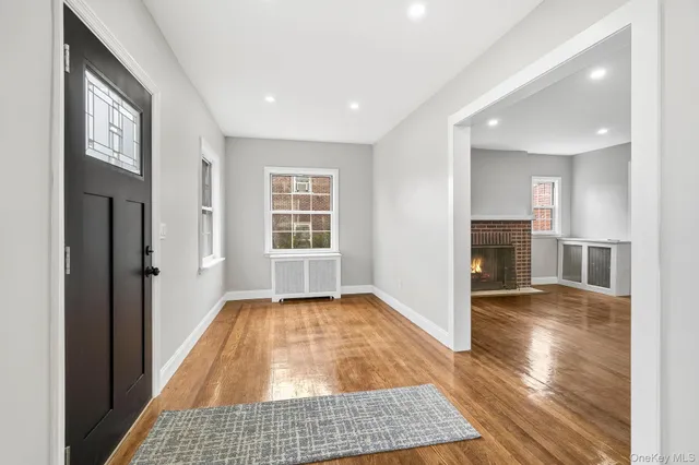 a view of a hallway with wooden floor and a living room