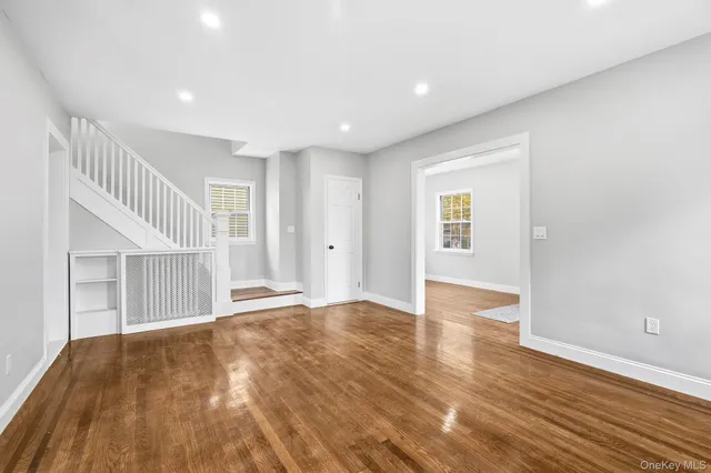 a view of an empty room with wooden floor and entryway