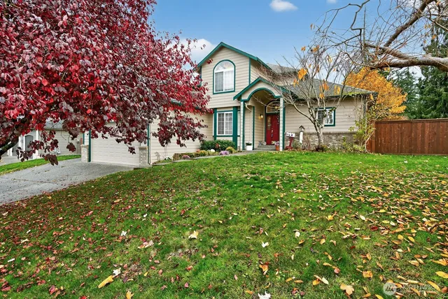 a view of a white house with a big yard and large trees